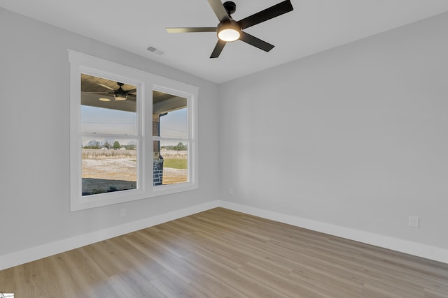 unfurnished room featuring light wood-type flooring, baseboards, visible vents, and a ceiling fan