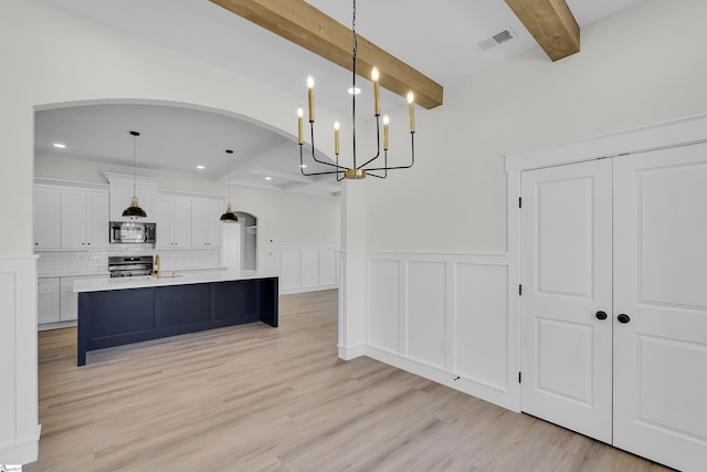 kitchen featuring white cabinetry, visible vents, appliances with stainless steel finishes, beam ceiling, and tasteful backsplash