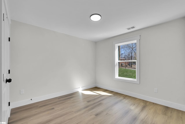 unfurnished room featuring baseboards, visible vents, and light wood finished floors