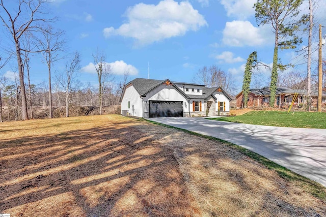 modern farmhouse style home with board and batten siding, a garage, stone siding, driveway, and a front lawn