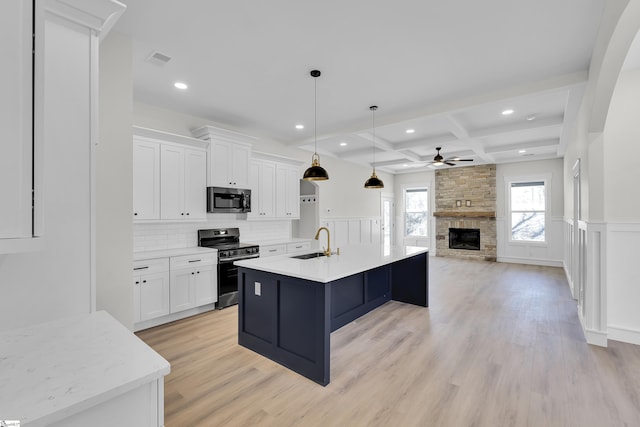 kitchen with coffered ceiling, a sink, white cabinets, stainless steel range with electric cooktop, and beam ceiling