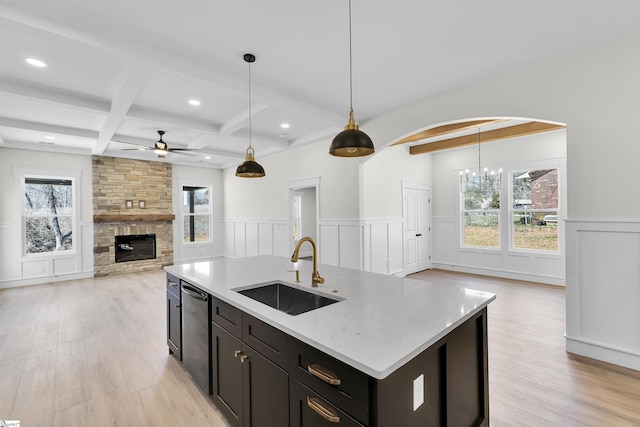 kitchen with a sink, open floor plan, dishwasher, beamed ceiling, and plenty of natural light