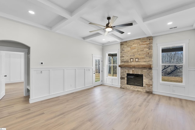 unfurnished living room with beam ceiling, a fireplace, light wood finished floors, visible vents, and coffered ceiling