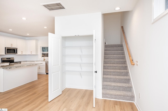 staircase with recessed lighting, visible vents, baseboards, and wood finished floors