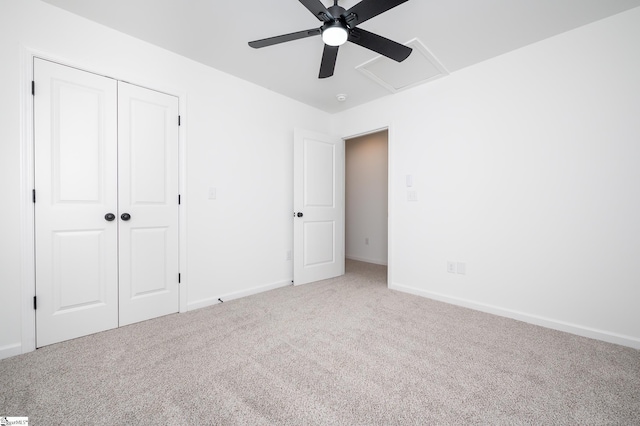 unfurnished bedroom with attic access, a closet, baseboards, and carpet flooring