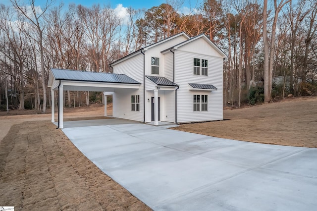 view of front of property with an attached carport, metal roof, and concrete driveway