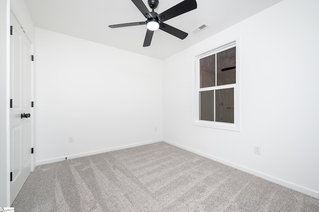 spare room featuring ceiling fan, carpet floors, visible vents, and baseboards