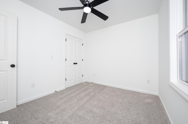 unfurnished room featuring a ceiling fan, carpet flooring, and baseboards