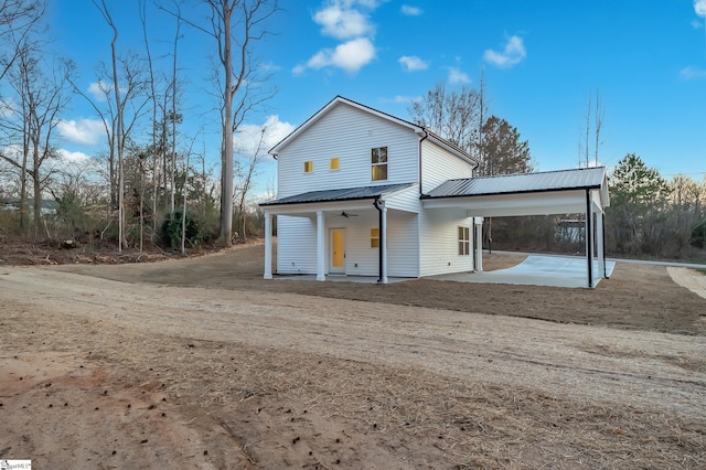 back of house with a ceiling fan, metal roof, and a patio