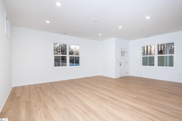 spare room featuring recessed lighting, light wood-style flooring, and baseboards