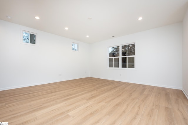 spare room with baseboards, light wood-style flooring, and recessed lighting