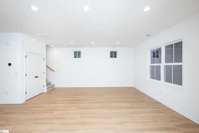 unfurnished room with recessed lighting, light wood-style flooring, and stairs