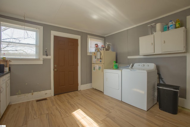 laundry area with cabinet space, visible vents, crown molding, light wood-style floors, and washing machine and dryer