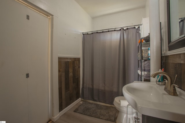 bathroom featuring wood finished floors, a sink, toilet, and a shower with curtain