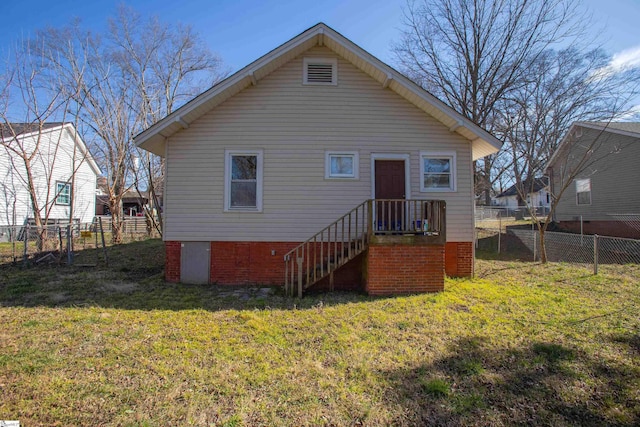 back of house featuring a lawn and fence