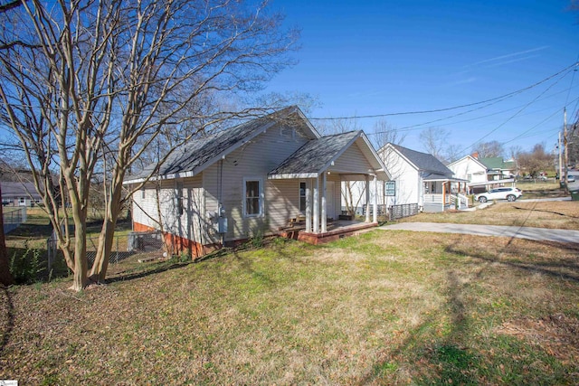 view of front of home featuring covered porch, fence, a front lawn, and concrete driveway