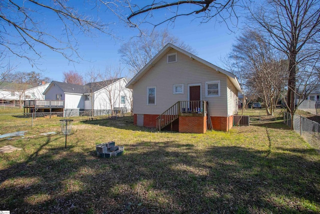 back of property with central AC unit, a lawn, and fence private yard