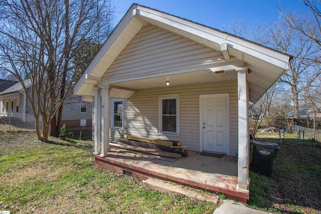 back of house featuring fence and a lawn