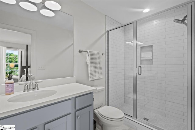 full bath with a stall shower, vanity, and toilet