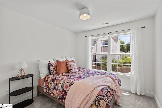 carpeted bedroom featuring visible vents and baseboards