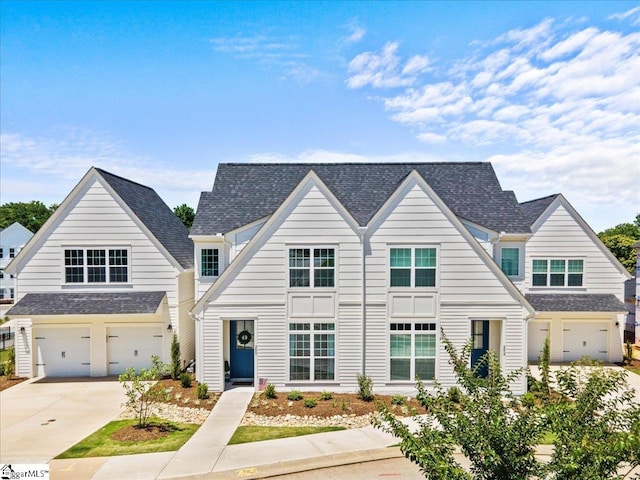 view of front of property featuring a garage, driveway, and a shingled roof