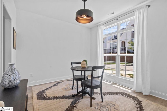 dining room with baseboards, visible vents, and wood finished floors