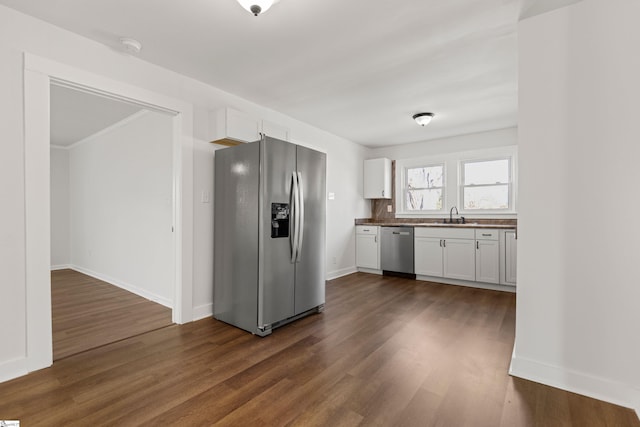 kitchen with dark countertops, appliances with stainless steel finishes, white cabinets, and dark wood finished floors