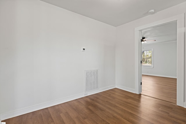 spare room featuring baseboards, visible vents, and wood finished floors