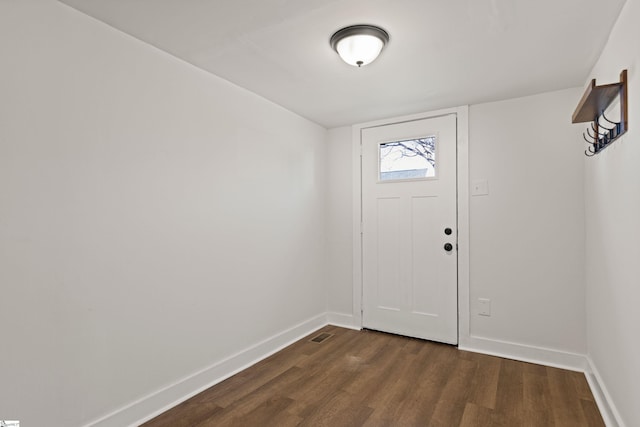 foyer entrance with dark wood-style flooring, visible vents, and baseboards