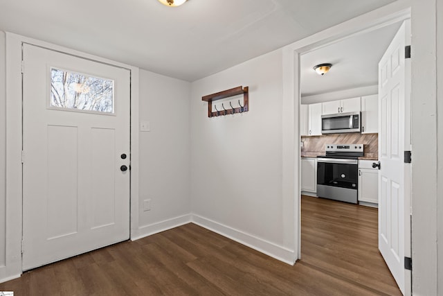 foyer featuring dark wood-type flooring and baseboards