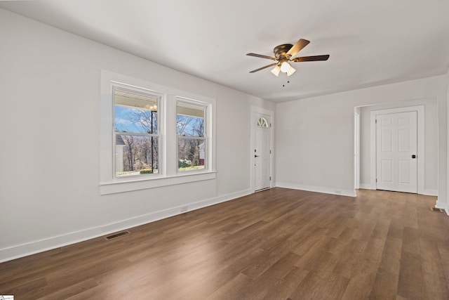 unfurnished room featuring a ceiling fan, baseboards, visible vents, and wood finished floors