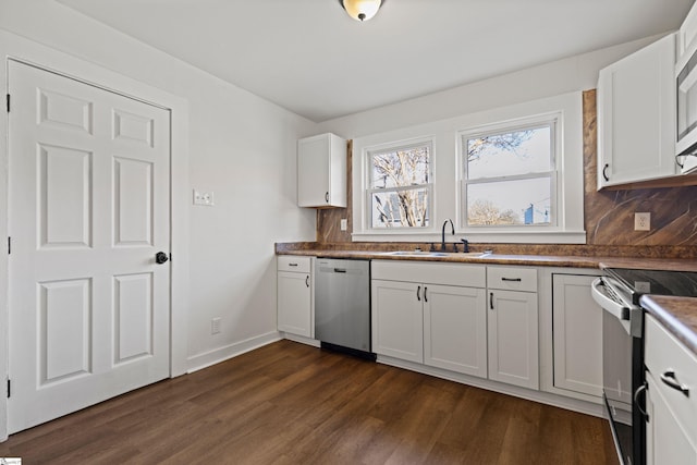 kitchen with a sink, white cabinetry, appliances with stainless steel finishes, decorative backsplash, and dark wood-style floors