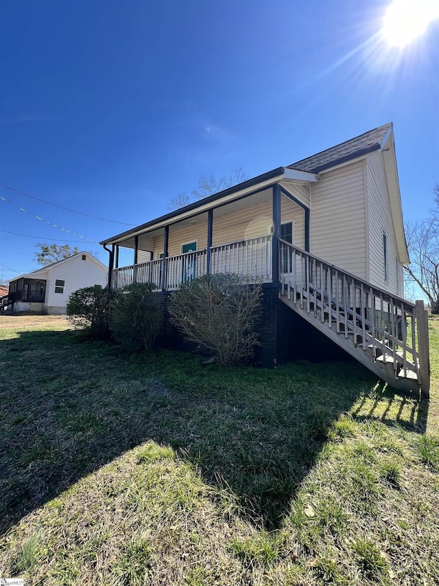 view of side of property with a yard and stairway