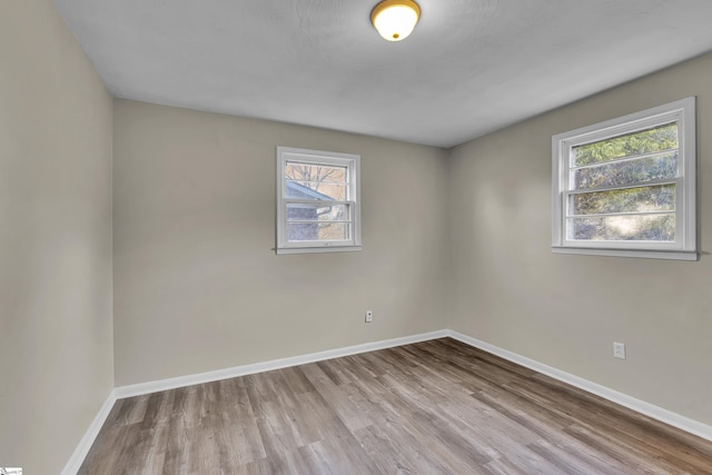 unfurnished room featuring baseboards and wood finished floors