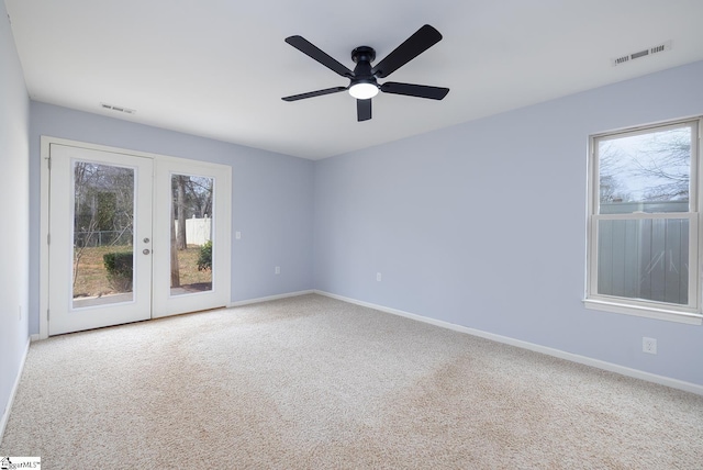 carpeted spare room with french doors, visible vents, and plenty of natural light