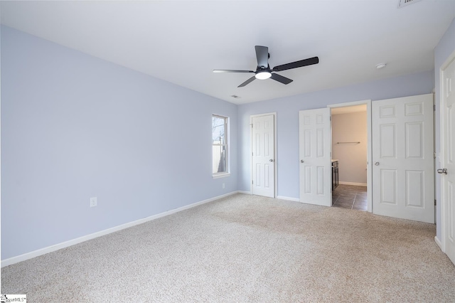 unfurnished bedroom featuring a ceiling fan, carpet, a closet, and baseboards