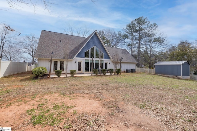 back of house featuring a fenced backyard, an outbuilding, french doors, a patio area, and central AC