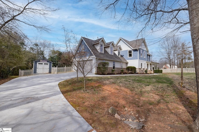 view of property exterior featuring an outbuilding, driveway, a shed, and fence