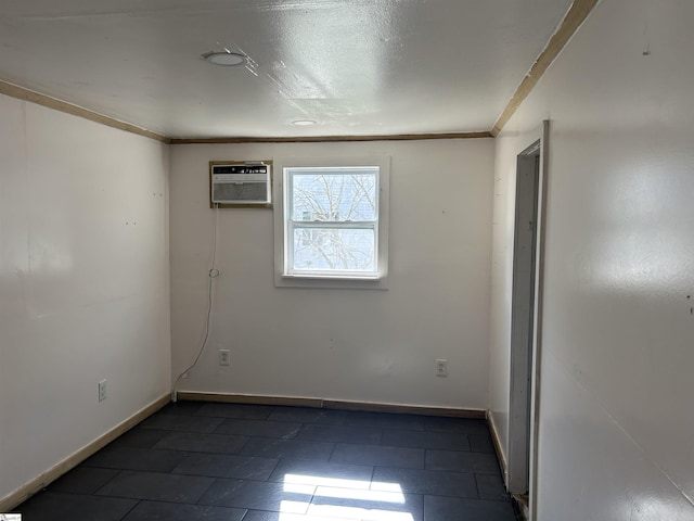 spare room with crown molding, baseboards, and a wall mounted AC