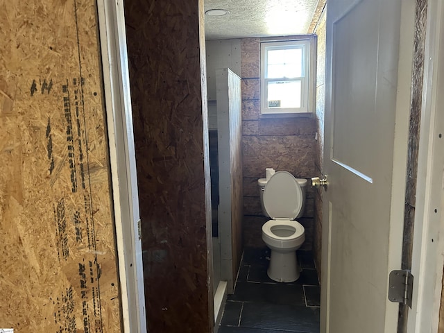 bathroom with a textured ceiling and toilet