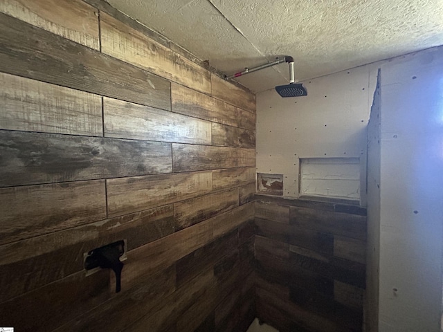 bathroom featuring a textured ceiling and walk in shower