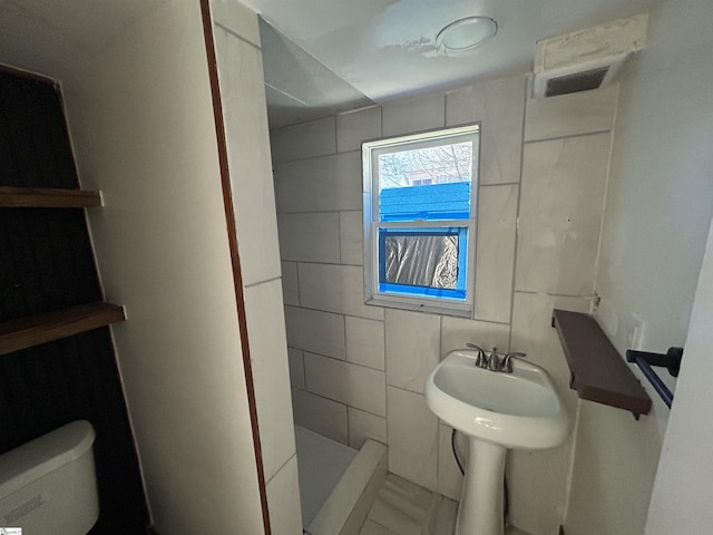 bathroom with visible vents, a shower stall, and toilet