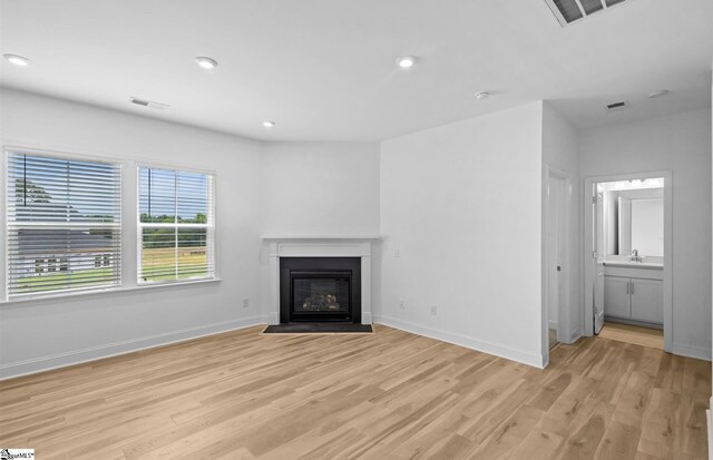 120 Indigo Cir Lot 35, Easley, SC 29642 - unfurnished living room featuring light wood-style flooring, a fireplace with flush hearth, recessed lighting, and baseboards