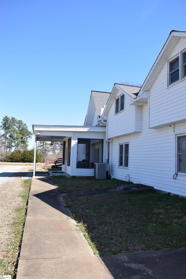 view of front of home with a front lawn and central AC