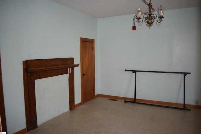 spare room featuring an inviting chandelier, baseboards, visible vents, and a textured ceiling