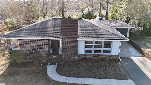 view of front of property featuring brick siding, a chimney, and roof with shingles