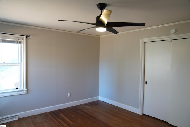 unfurnished bedroom featuring ornamental molding, visible vents, baseboards, and dark wood-style floors