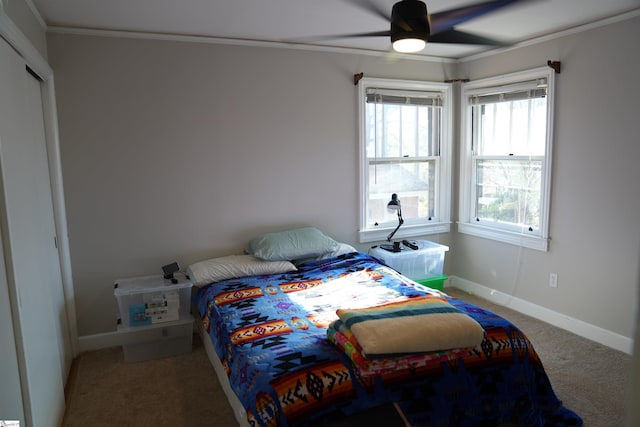 bedroom featuring a ceiling fan, carpet, crown molding, and baseboards