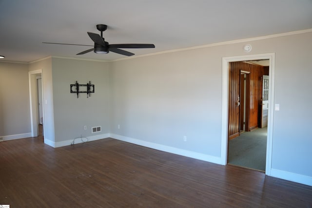 spare room featuring ornamental molding, dark wood-style flooring, visible vents, and baseboards