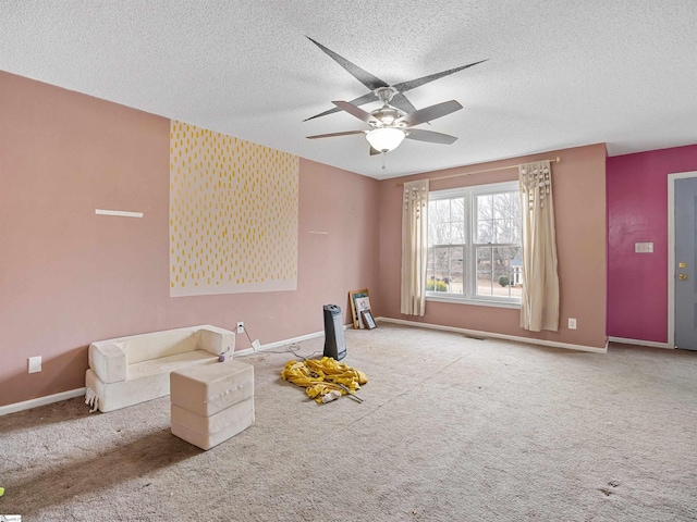 interior space featuring a textured ceiling, ceiling fan, visible vents, and baseboards